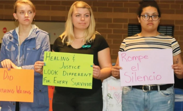 Students holding up anti-violence signs at the 2019 Take Back the Night event