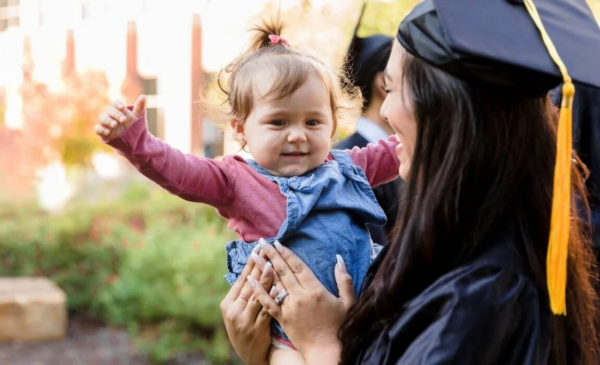 Graduate holding baby